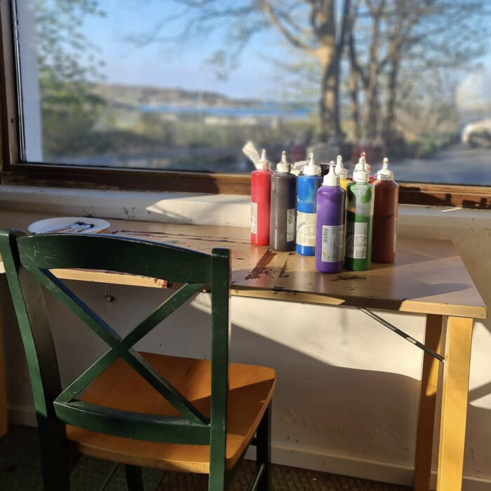 Målarfärger på ett bord vid ett fönster med utsikt över Askimsviken