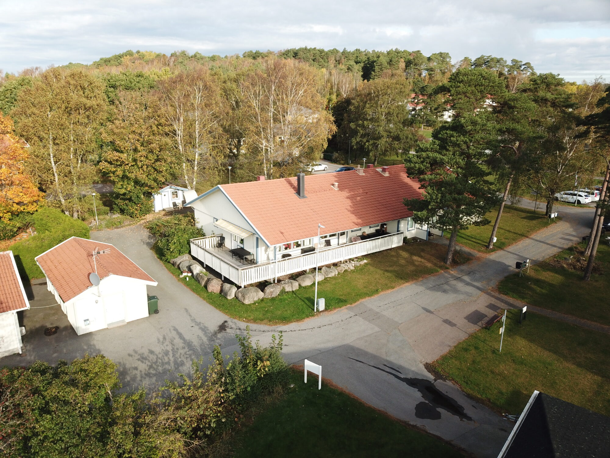 Lekullevägens gruppbostad,flygvy över vit byggnad med rött tak omgiven av träd och gård