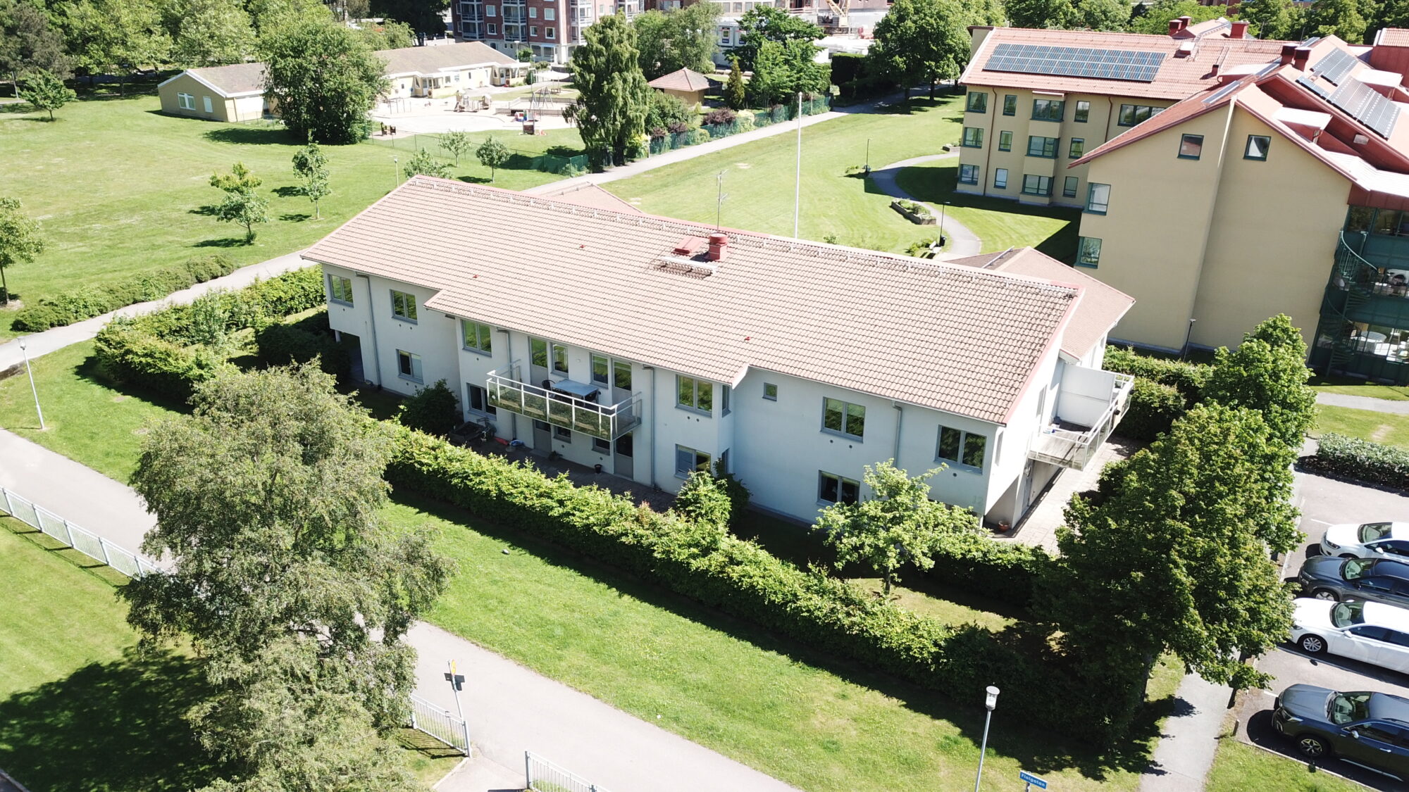 Fiolgatans servicebostad, flygvy över avlång bostadsbyggnad med grönområde runt