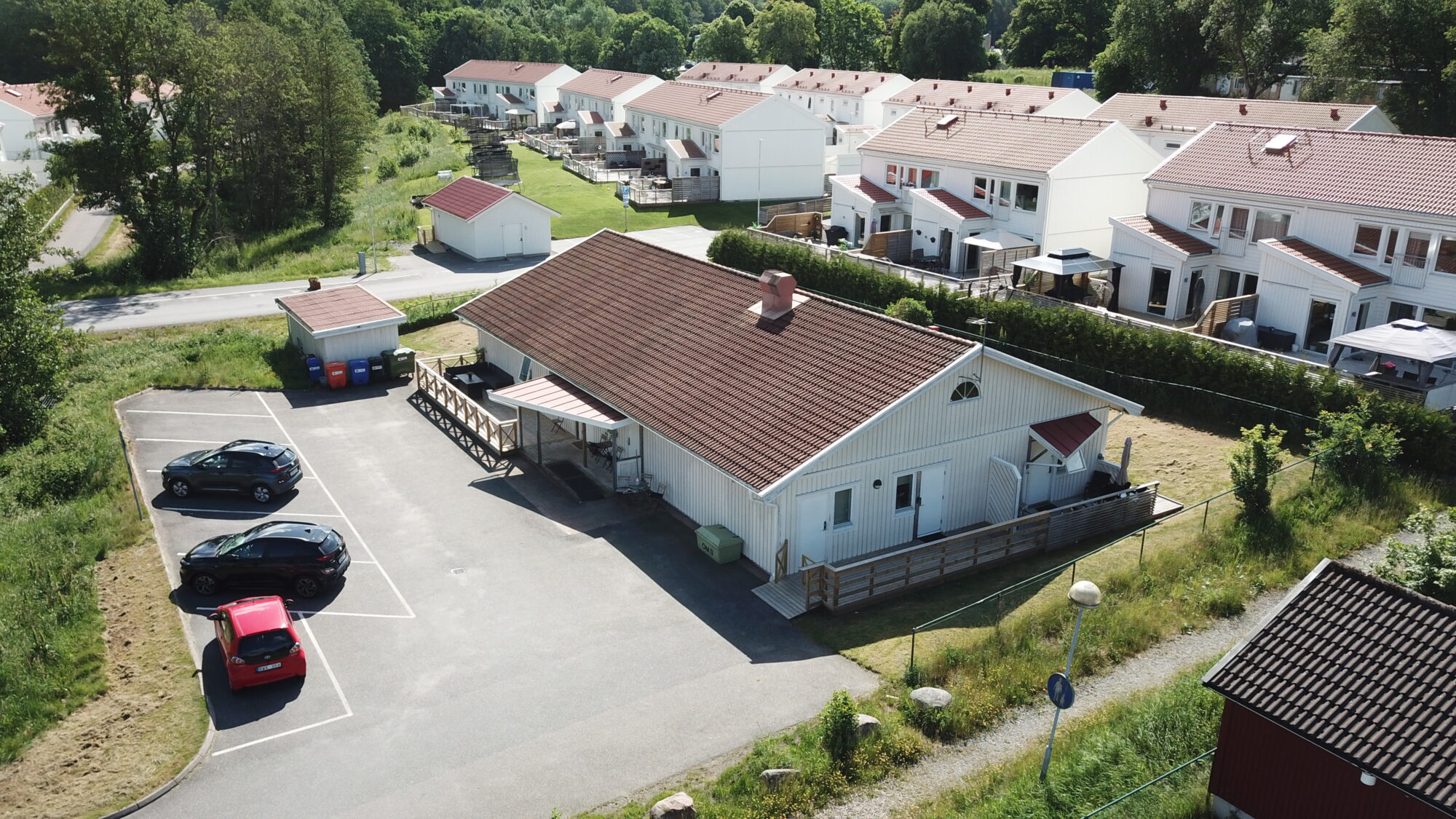 Sagas gruppbostad,flygvy över enplanshus med parkering och radhus i bakgrunden