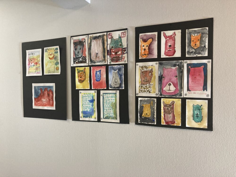 Tre svarta väggmonterade ramar med flera små, färgglada illustrationer ordnade i rutnät.