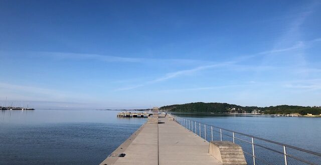Brygga som sträcker sig ut över lugnt vatten i Askimsviken