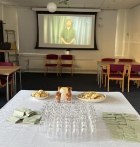 Ett dukat bord med vit duk, champagneglas, servetter och snacks.