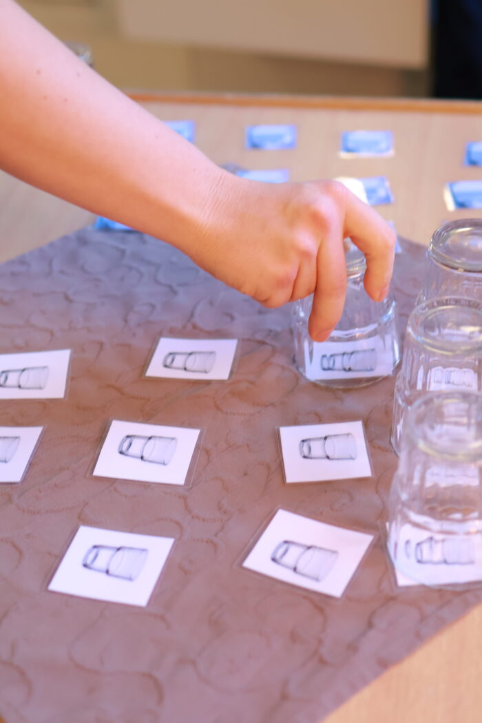 Hand som placerar små symbolkort på ett bord i ett rutmönster