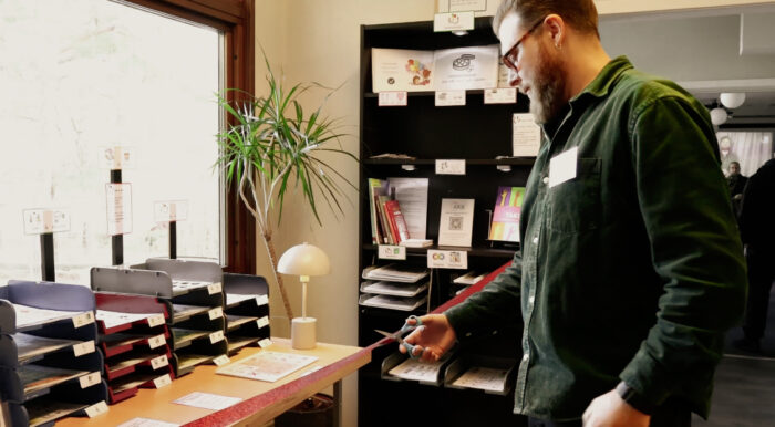 Bild på en person som klipper ett rött siden band