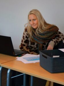 Person sitter vid ett bord med laptop framför sig