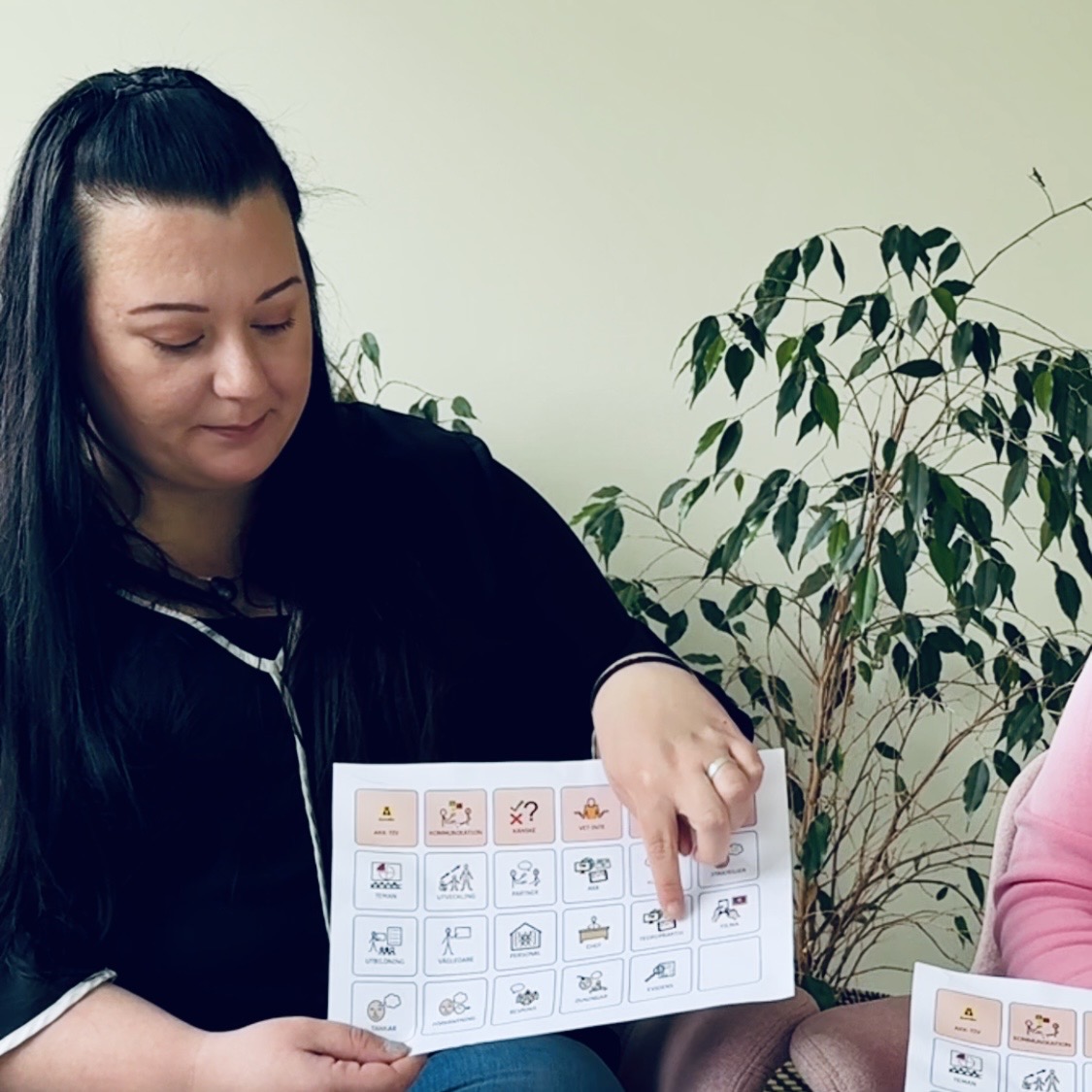 Matilda sitter i fåtölj med samtalskarta i handen