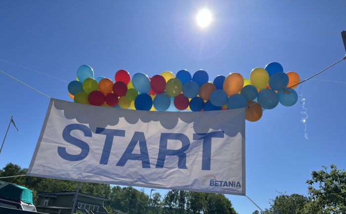 Ballonger, en skylt "start" och några människor.